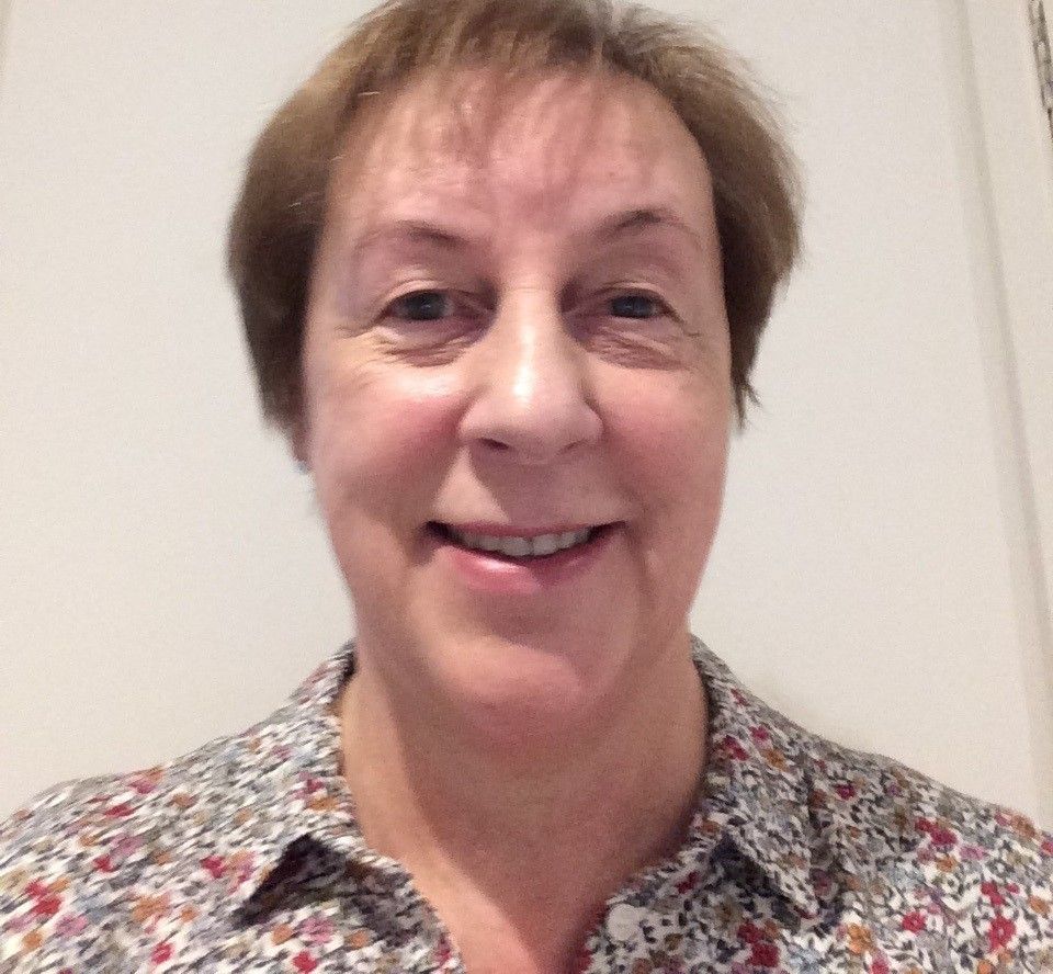 Headshot of Marie Curie Companion, Maria Meaker. She is smiling and wearing a floral blouse.