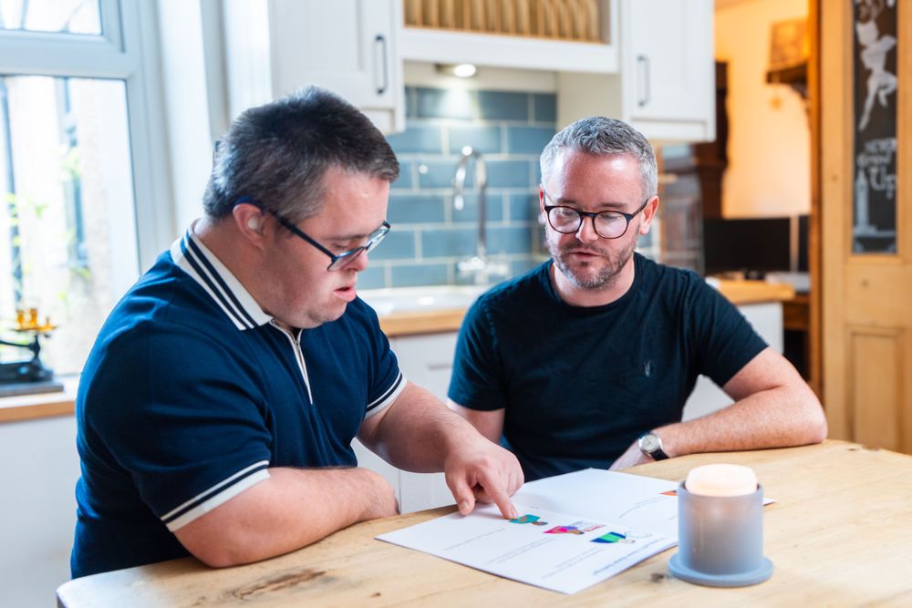 Two men looking at an Easy Read booklet.