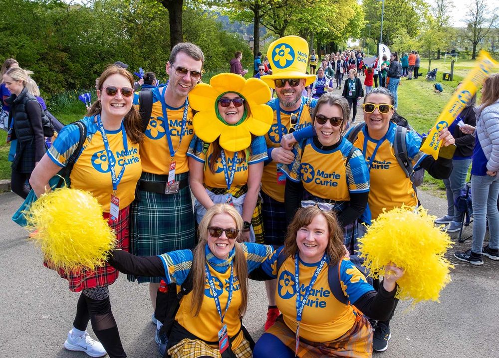 A group of fundraisers smile and pose for a photograph after taking part in the Kiltwalk event