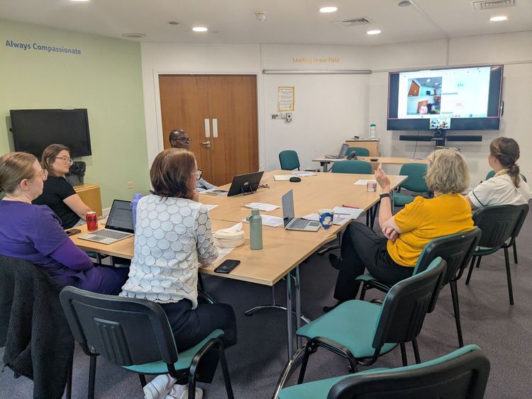 Journal club session with people sitting around a meeting table