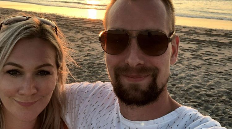 Joost and Stacey smiling on a beach at sunset