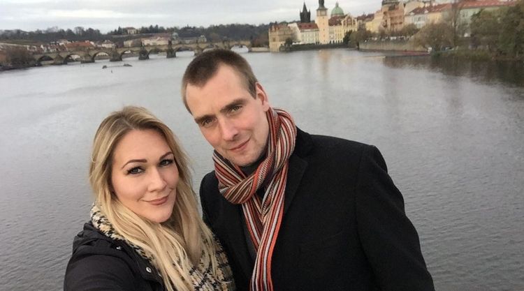 Joost and Stacey smiling and standing by a river