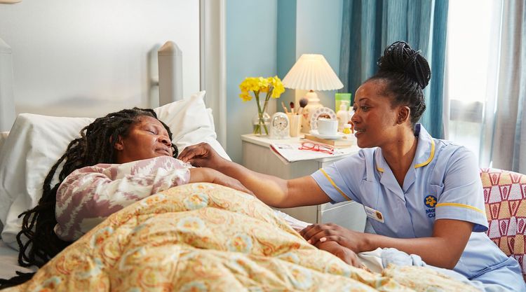 Marie Curie nurse sits with a patient in a hospice 