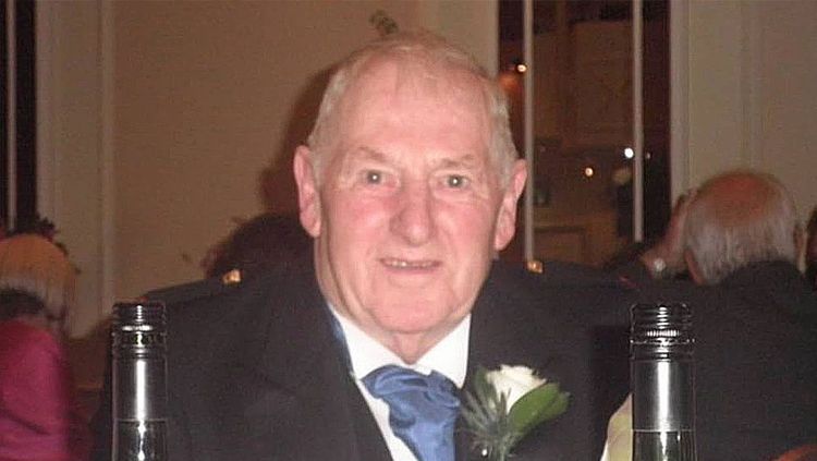 Natalie's grandad Graham is seated at a dinner table wearing a suit