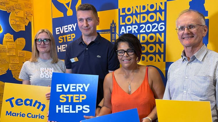 To The End Team hold placards that say 'Team Marie Curie' and 'Every Step Helps'