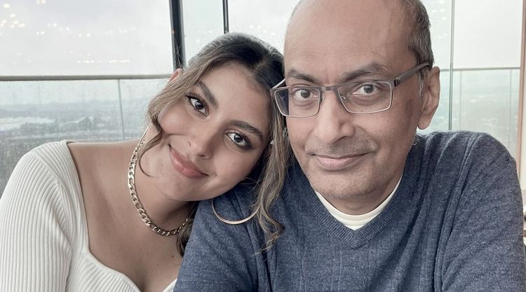 Serena with her father, Harmi. They are both smiling at the camera and she has her head on his shoulder.