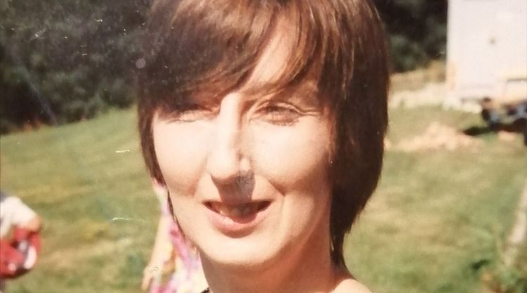 Yvonne smiling in greenery the sun