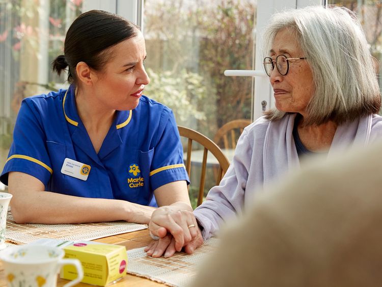 A Marie Curie Nurse speaks with a patient
