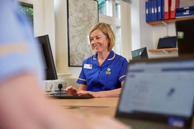A nurse looks at a computer