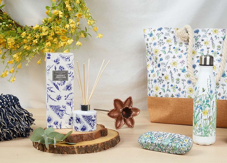 Marie Curie merchandise featuring a floral bag, floral water bottle and floral glasses case.